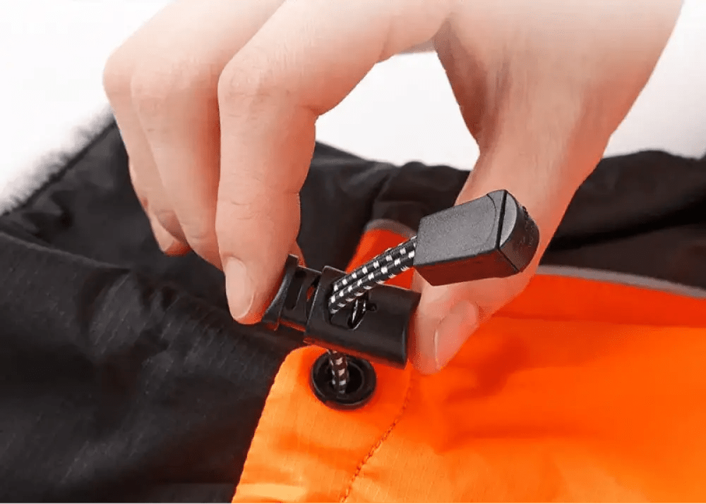 Main ajustant un cordon à pois sur un manteau pour chien Truelove Snow imperméable