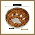 Gamelle anti-glouton pour chien en inox avec motif patte, remplie de croquettes