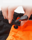 Main ajustant le cordon noir du manteau Truelove Spring imperméable avec bandes réfléchissantes